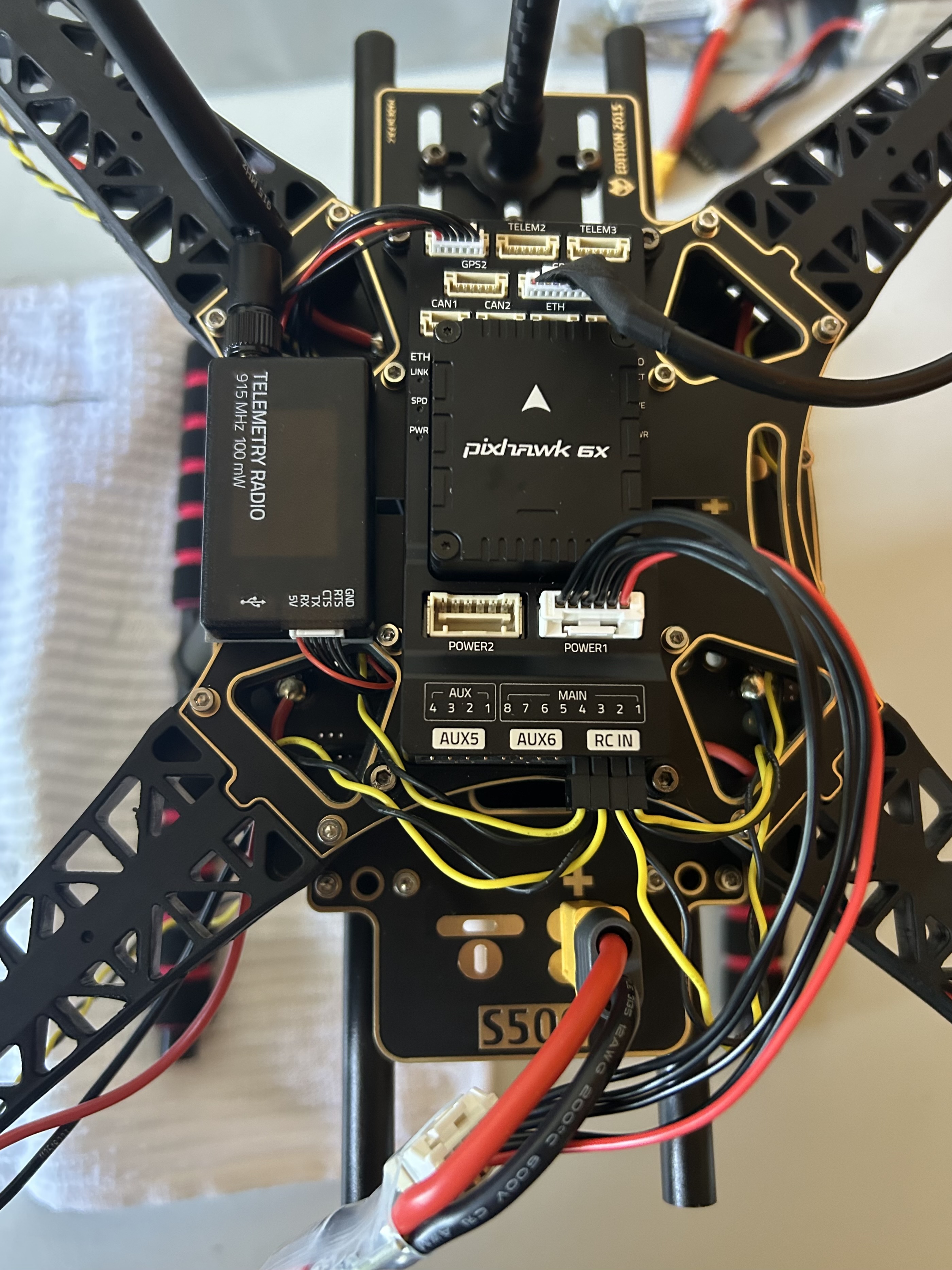 Top-down view of the Holybro S500 with Pixhawk 6X, telemetry radio, power wiring, and signal leads installed.